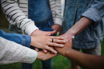 Close-up of diverse group of friends stacking their hands together in circle, Friendship and lifestyle concepts