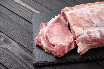 A large piece of pork loin on a rustic dark background.