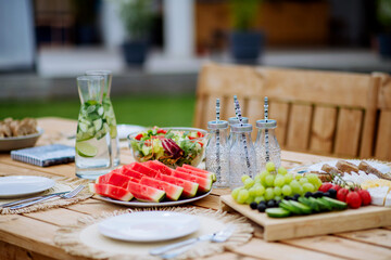 Dining table set for dinner on the terrace in summer, garden party concept.