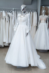 white wedding dresses on mannequin and away hanging on hangers