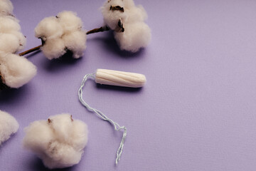 Women menstrual cycle theme. Tampon with cotton on purple background