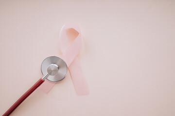Pink ribbon breast cancer and stethoscope on a pink background with copy space