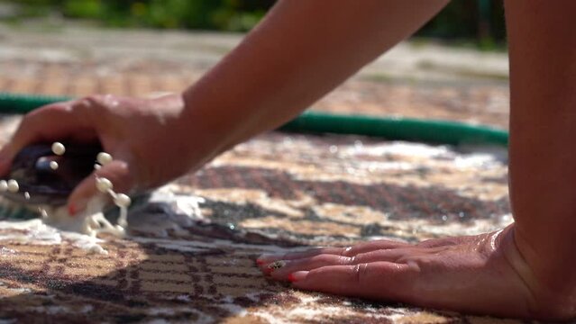 Woman manually washes the carpet . Hand wash the carpet. Carpet washing manually. Close-up