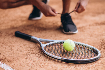 Young man tennis player at the court, tennis racket close up