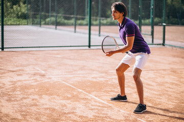 Young man tennis player at the court