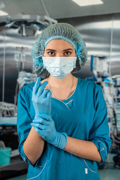 female doctor in operating room in a special uniform injecting medicine through the patient.