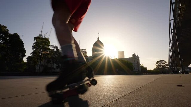 Slow motion of woman rollerskating at Melbourne Royal Exhibition Building at sunset, Australia