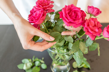 Woman hands taking care of a rose bouquet