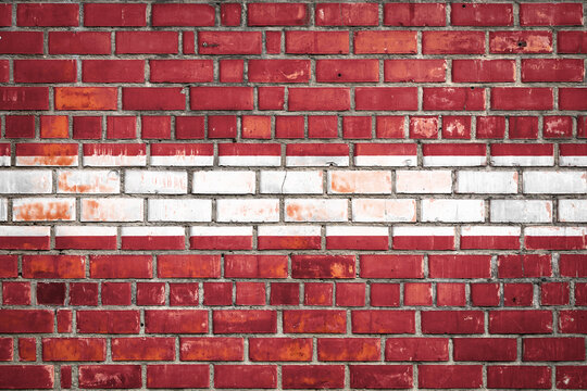 National  flag of the  Latvia on a grunge brick background.