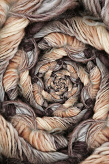 ball of coloured wool making a complex design structure on black background