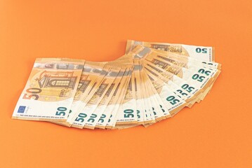 euro banknotes on a orange background