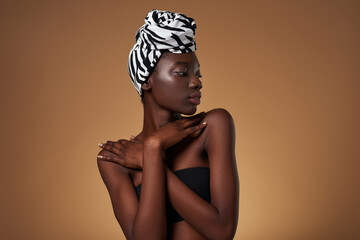 Black girl wearing african turban touching herself