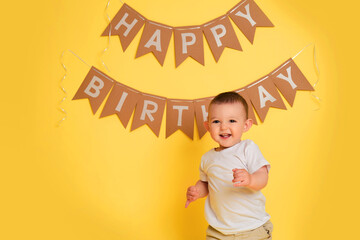 Decorations on a studio yellow background for celebrating the first birthday of a child, one year old baby