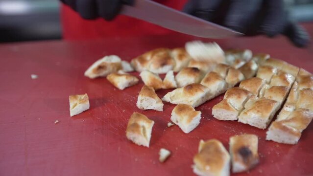 Pita, slicing pitas with a knife.
The master who slices the pitas to put under the meat. Turkish Iskender kebab making.
