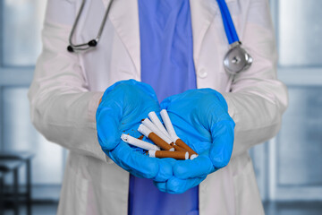 Woman doctor holding broken cigarettes with tobacco in her hands, clinic background - Powered by Adobe