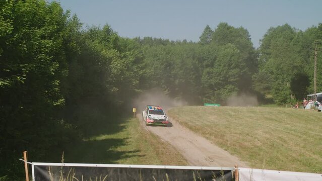 Rally car driving towards the camera and under a bridge - extreme slow motion