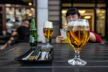 Two glasses of beer over the sidewalk table