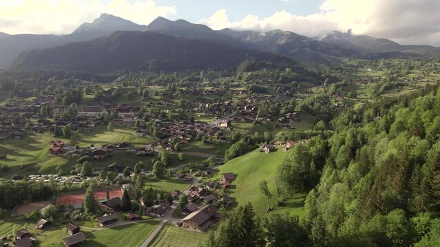 aerial drone footage orbiting over beautiful mountain village in the swiss alps
