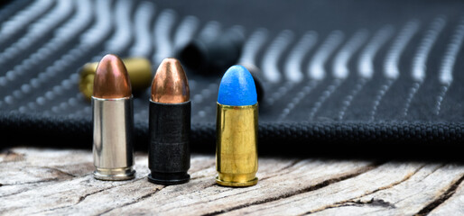 9mm pistol bullets and bullet shells on wooden table, soft and selectivec focus.