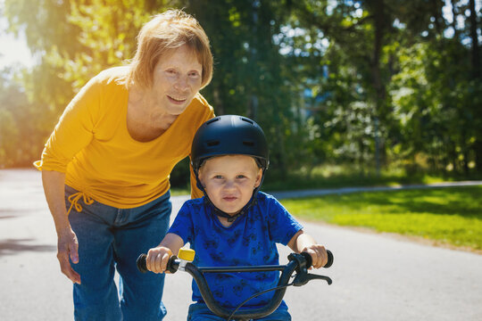 grandmother teaching his grandson to ride a bicycle. child learning to ride a bike