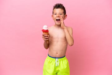 Little caucasian boy eating an ice-cream isolated on pink background shouting with mouth wide open