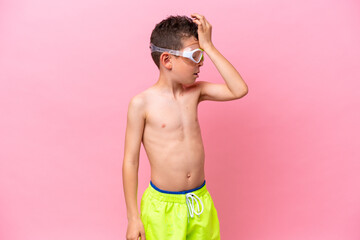 Fototapeta premium Little caucasian boy wearing a diving goggles isolated on pink background has realized something and intending the solution