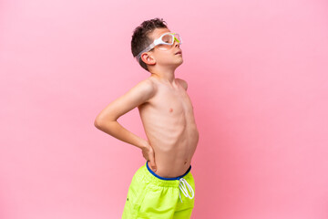 Fototapeta premium Little caucasian boy wearing a diving goggles isolated on pink background suffering from backache for having made an effort