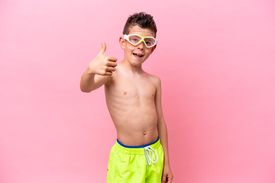 Little caucasian boy wearing a diving goggles isolated on pink background with thumbs up because something good has happened