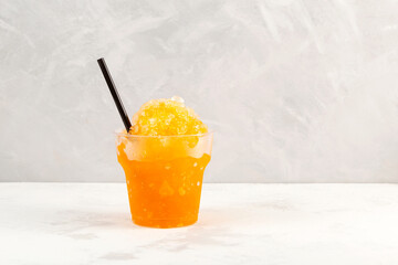 Slushie drink in disposable plastic cup. Orange Granizado. Refreshing summer iced drink. Sweet...