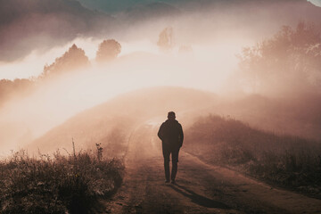 Fototapeta premium man walking in a foggy autumn landscape