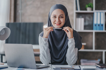 happy muslim business women in hijab at work smiling arab woman taking notes and work on laptop