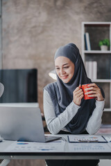 happy muslim business women in hijab at work smiling arab woman taking notes and work on laptop