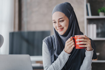 happy muslim business women in hijab at work smiling arab woman taking notes and work on laptop