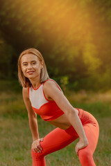 Portrait of young smiling woman doing yoga pose in summer forest