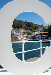 Fototapeta premium View through a sign the fishing village of cudillero