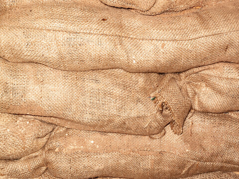Sandbags background stacked in a heap for use as flood defence or for the military as a barricade, stock photo image