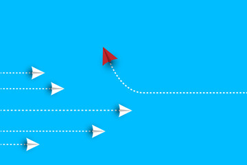 Group of white paper plane in one direction and one red paper plane pointing in different way on blue background.