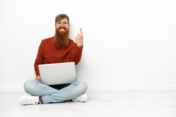 Young reddish caucasian man with laptop isolated on white background doing coming gesture