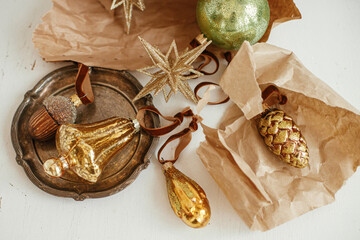 Stylish christmas ornaments flat lay. Golden vintage baubles on craft paper, festive composition on...
