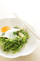 Chinese food, Pea sprouts stir fried vegetable with sunny side up fried egg on top