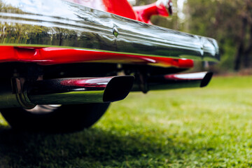 Chrome bumper on a red car with twin chrome exhaust pipes