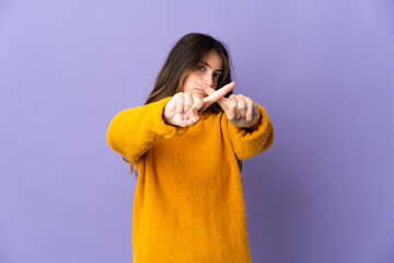 Young caucasian woman isolated on purple background making stop gesture with her hand to stop an act