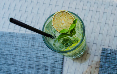 Refreshing drinks mojito cocktails with berries lime crushed ice on a blurred background.