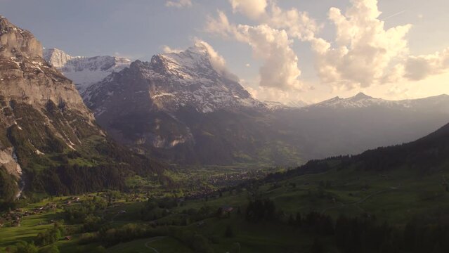 Aerial drone footage raising down with views of picturesque mountain village in front of eiger north face