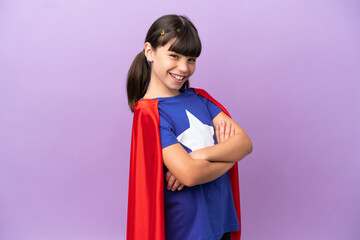 Little kid isolated on purple background in superhero costume with arms crossed © luismolinero