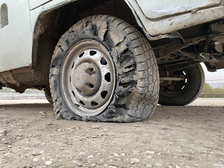 Fototapeta na wymiar Flat tire of SUV after driving on a mountain road