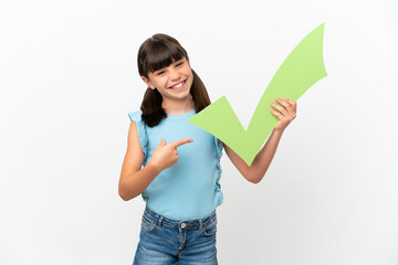 Little caucasian kid isolated on white background holding a check icon and pointing it