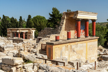Knossos palace in Heraklion, Crete island, Greece. Details of ancient architecture - red Minoan columns and wall painting. Travel vacation concept.