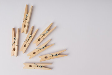wooden clothespins lie in a corner on a white background with copy space