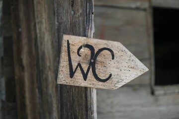 Closeup of a WC wooden sign on the wall